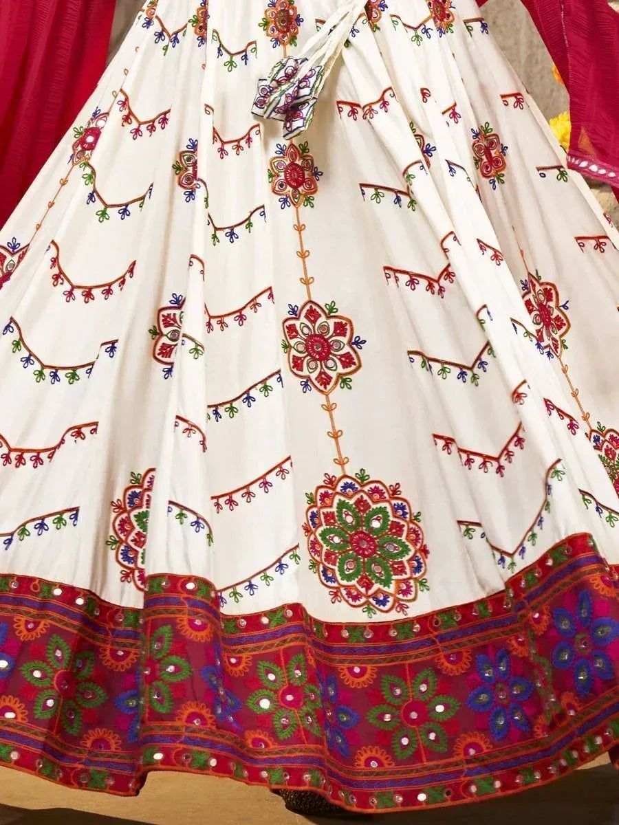 White embroidered lehenga with colorful floral motifs and mirror work border, ethnic Indian wear