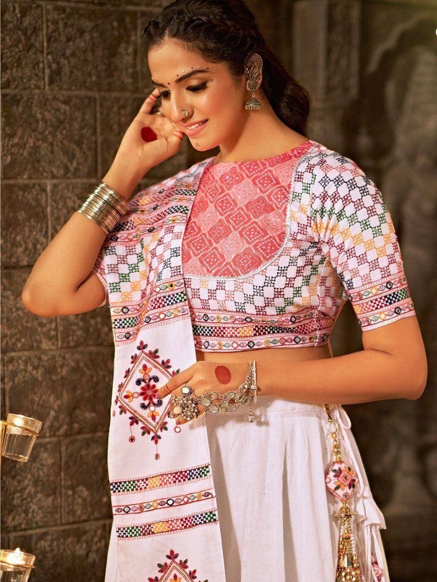 Woman in colorful embroidered ethnic top with white skirt and dupatta, traditional Indian wear