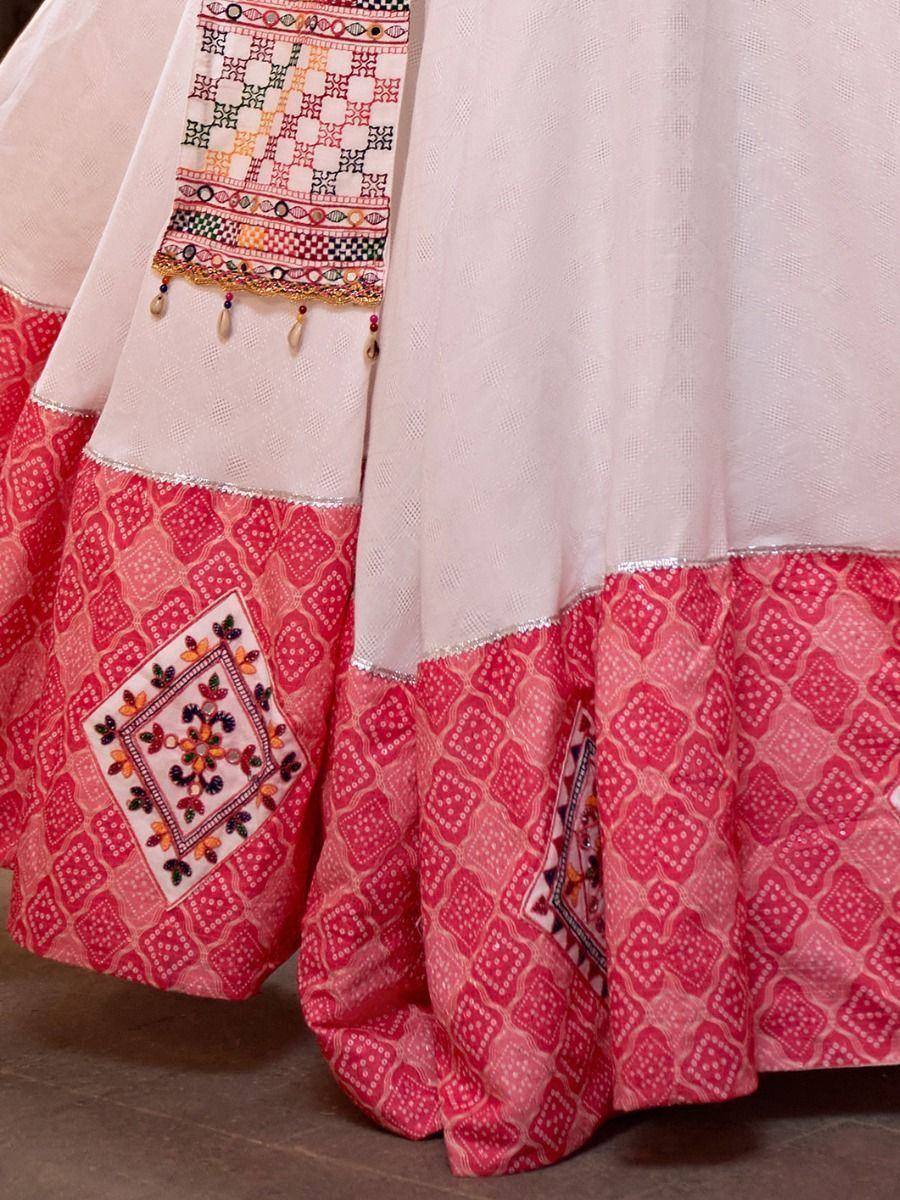 Pink and white ethnic lehenga with intricate embroidery and geometric patterns, perfect for Indian weddings or festivals.