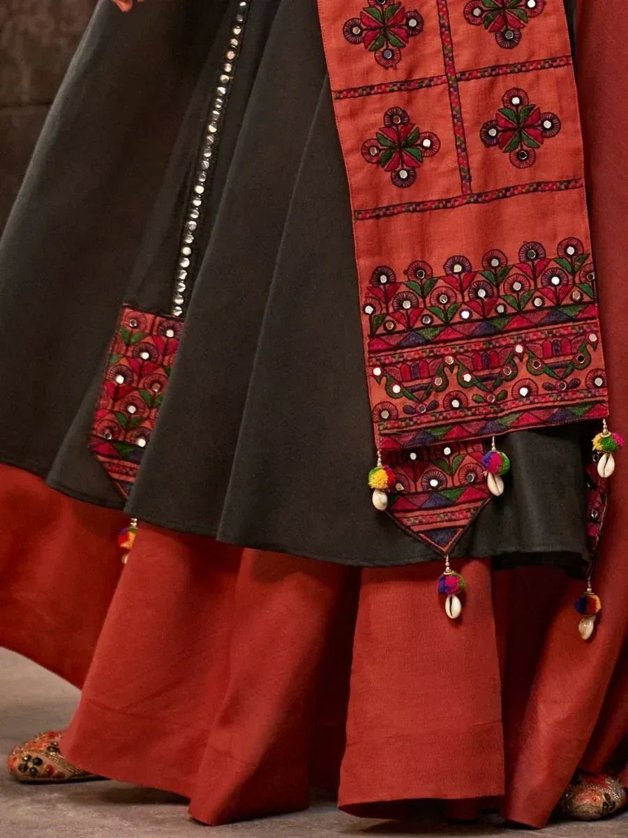 Black and rust ethnic lehenga with mirror work, floral embroidery, and pom-pom tassels