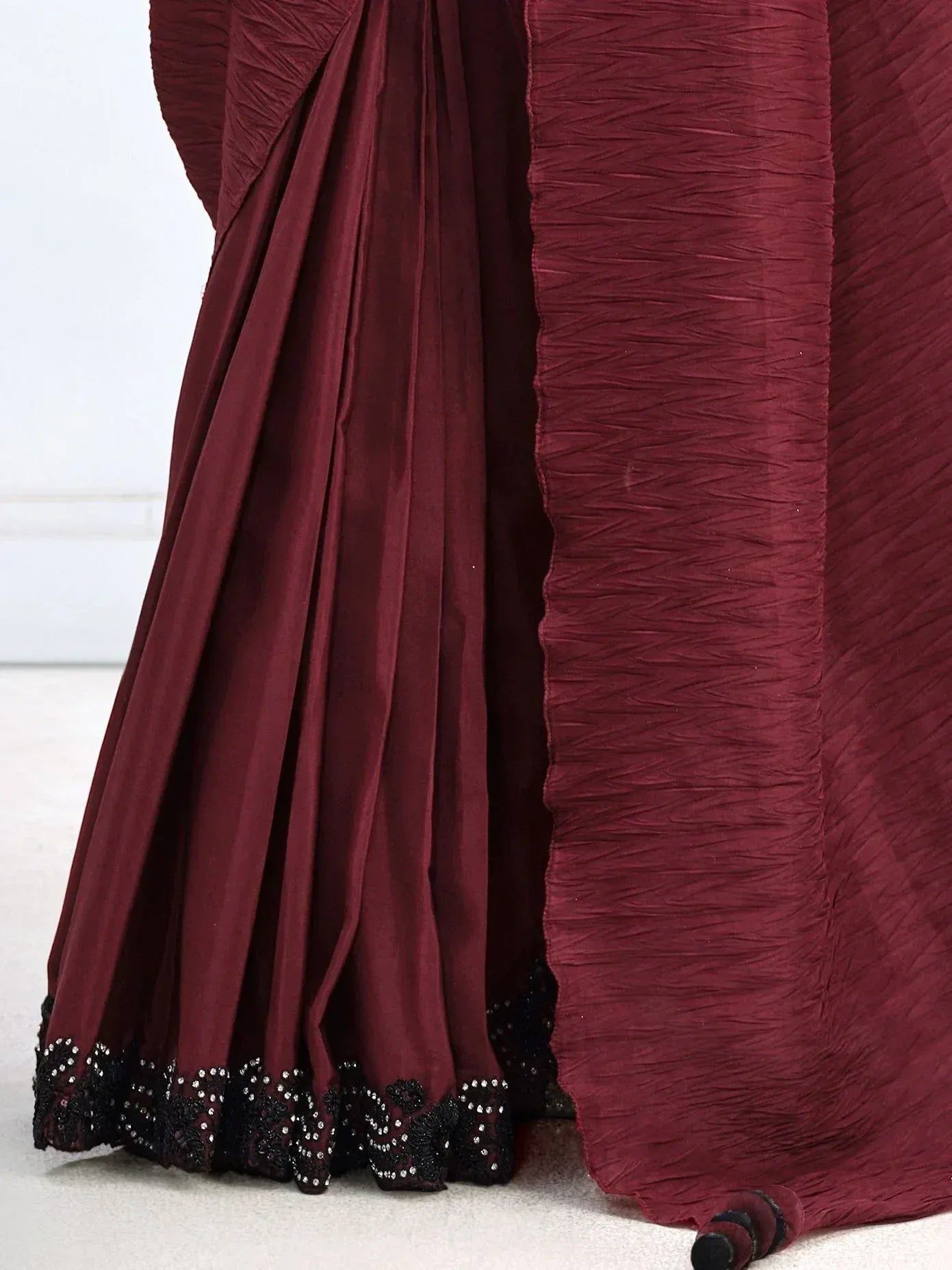 Deep maroon saree with black sequin border and crinkled texture, elegant ethnic wear