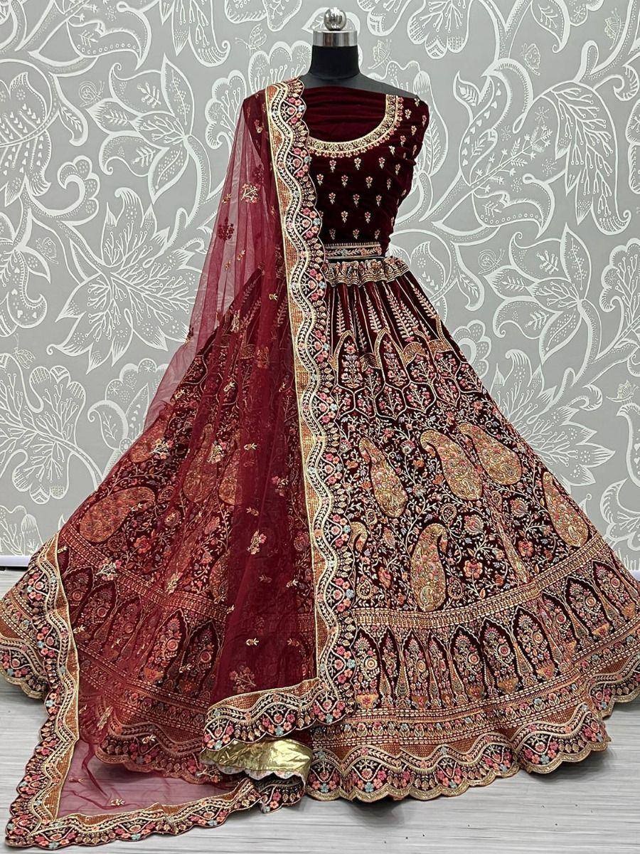 Maroon velvet lehenga choli with intricate gold embroidery and matching dupatta, perfect for weddings and festive occasions.