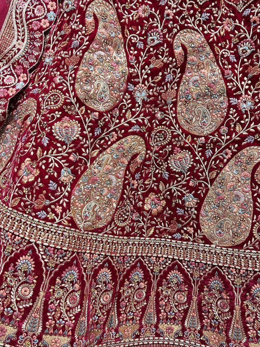 Rich maroon velvet lehenga with intricate paisley and floral embroidery, perfect for Indian ethnic wear.
