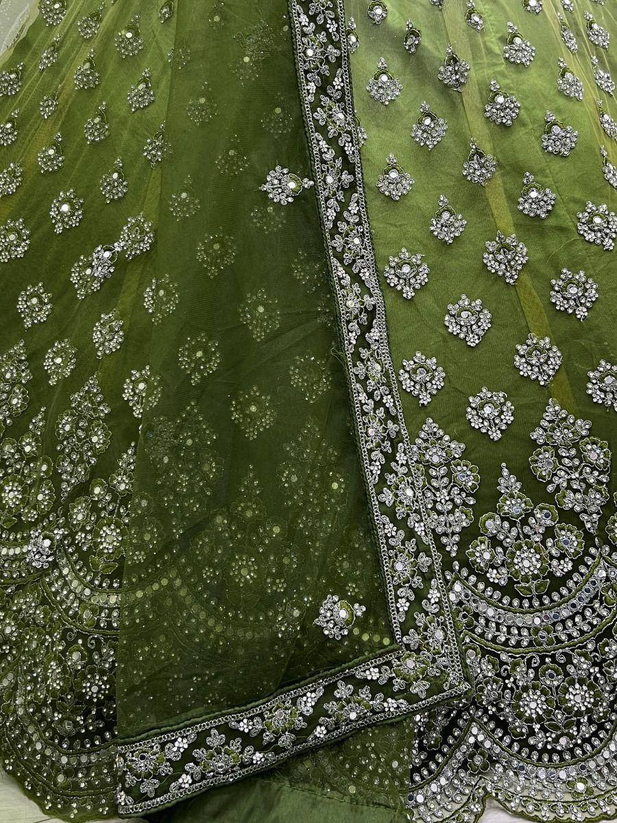 Emerald green lehenga choli with intricate silver embroidery and mirror work, perfect for Indian ethnic wear.
