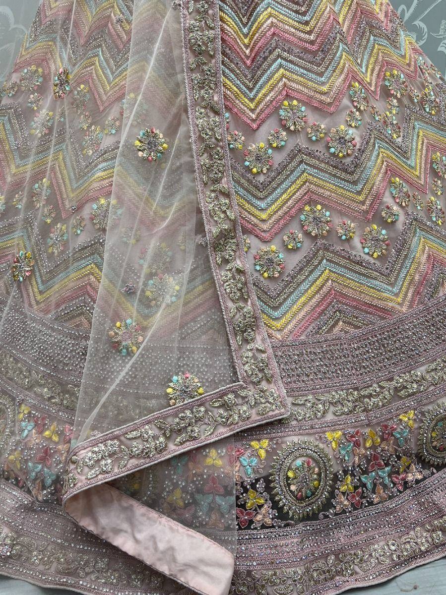 Designer lehenga choli with colorful zigzag embroidery and floral motifs, perfect for Indian ethnic wear.