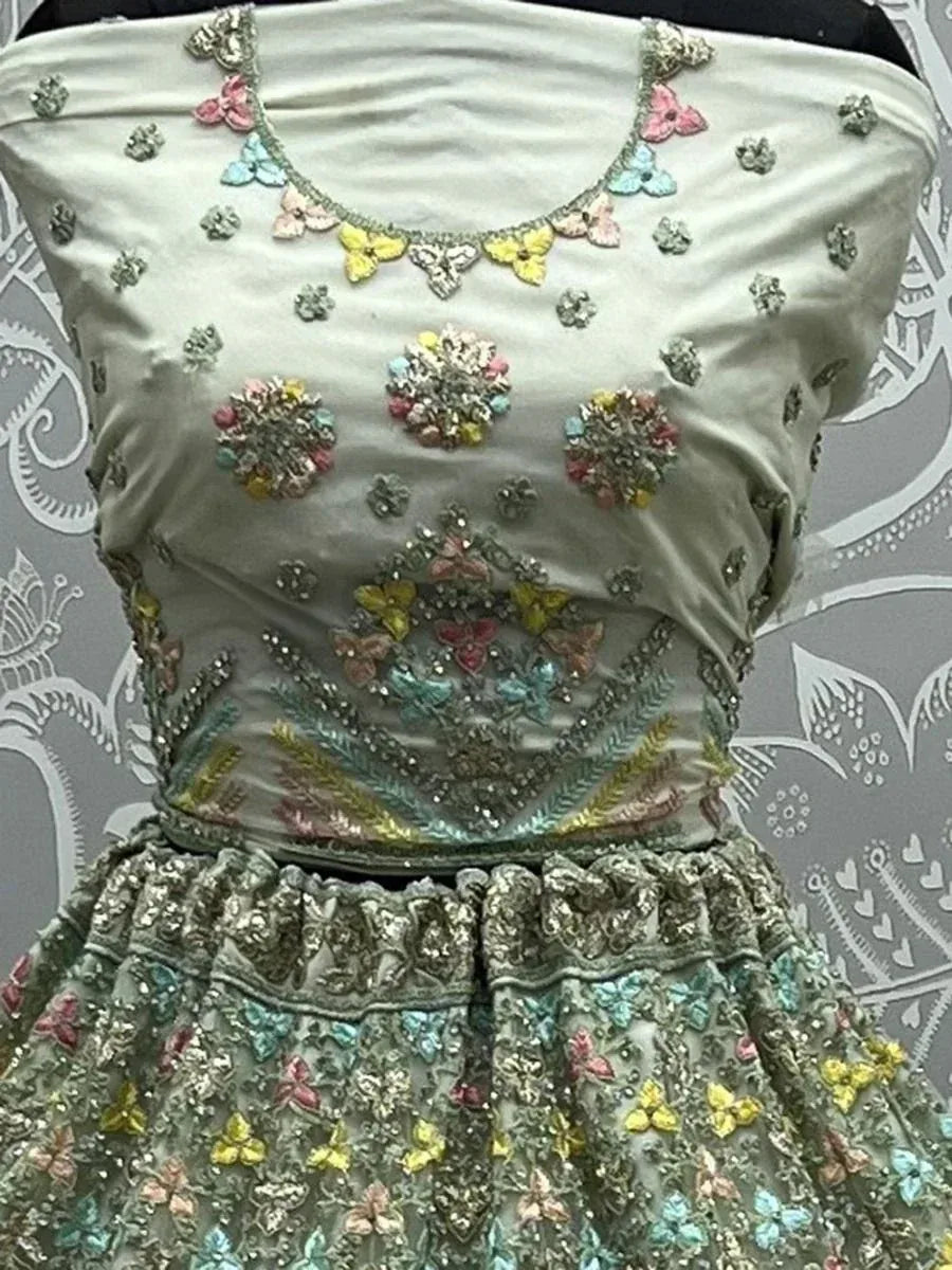 Pastel green lehenga choli with floral embroidery and butterfly motifs, perfect for Indian ethnic wear occasions.