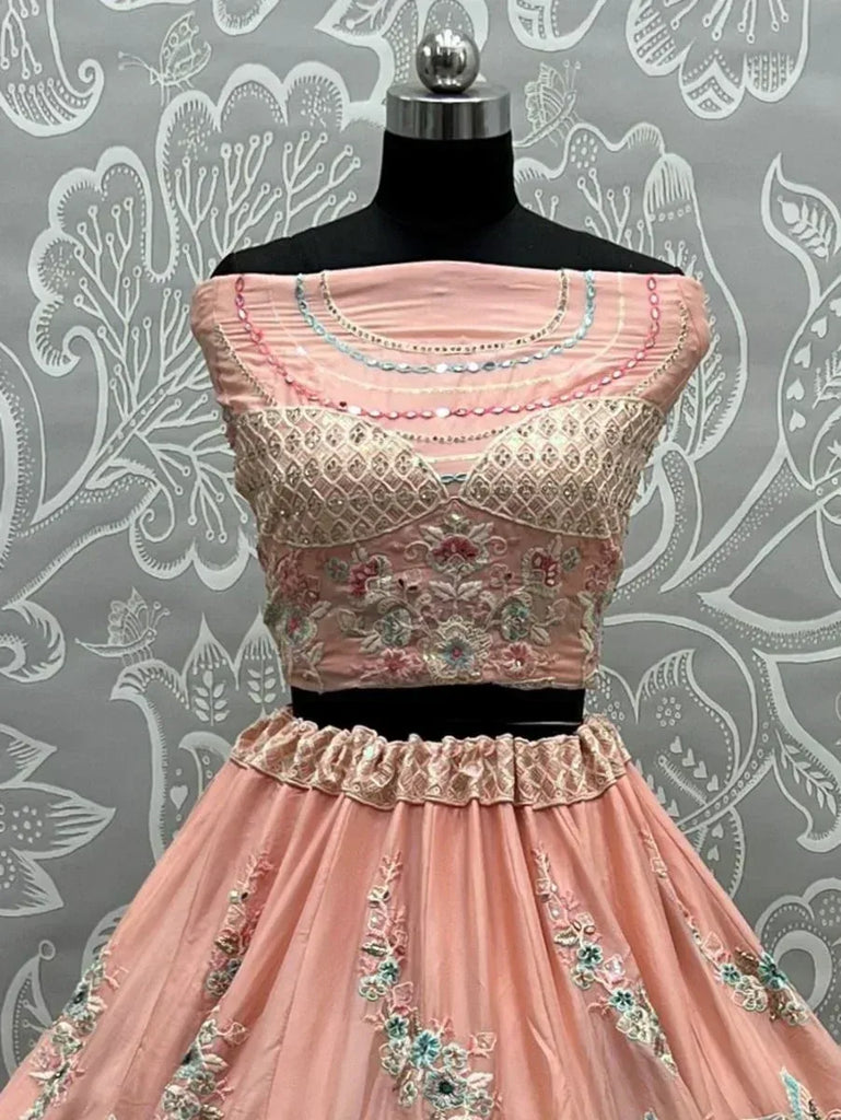 Pink embroidered lehenga choli with floral motifs and sequin detailing, displayed on mannequin