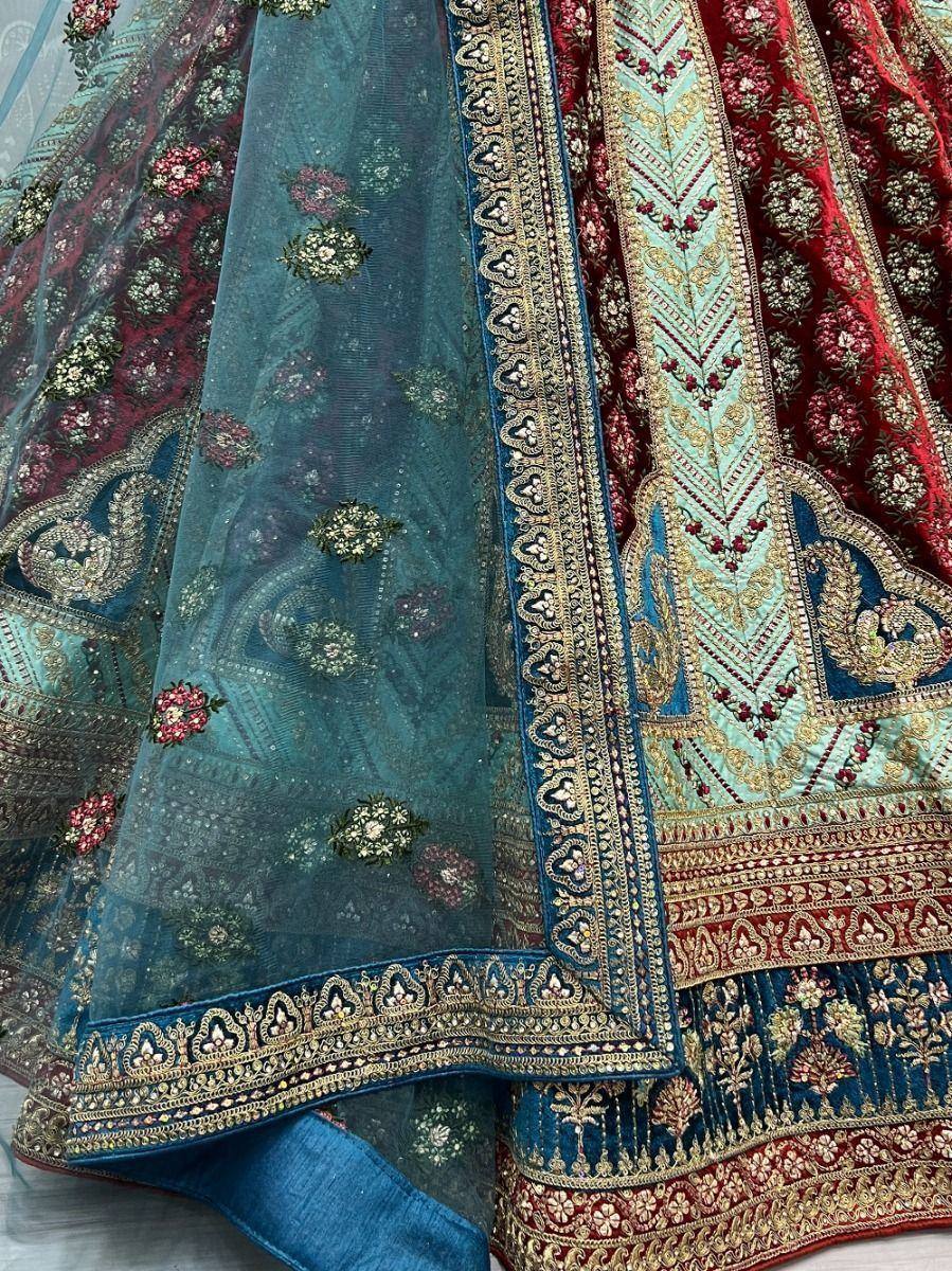 Designer lehenga choli with intricate floral embroidery and gold border detailing in teal and red