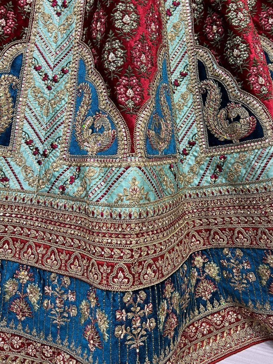 Luxury Indian lehenga with peacock embroidery, floral motifs, and intricate gold threadwork in blue, red, and mint.