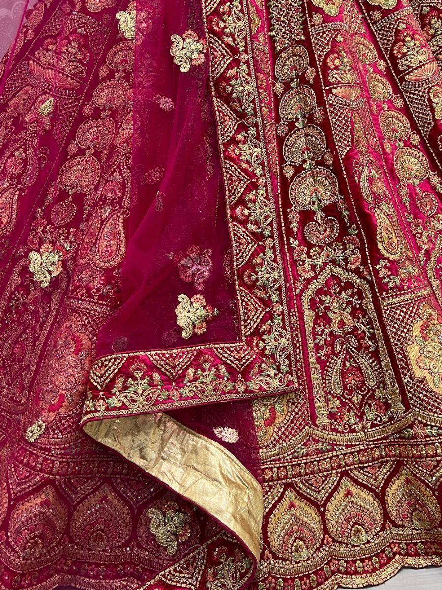 Rich maroon velvet lehenga with gold embroidery and paisley motifs, perfect for Indian weddings and festive occasions.