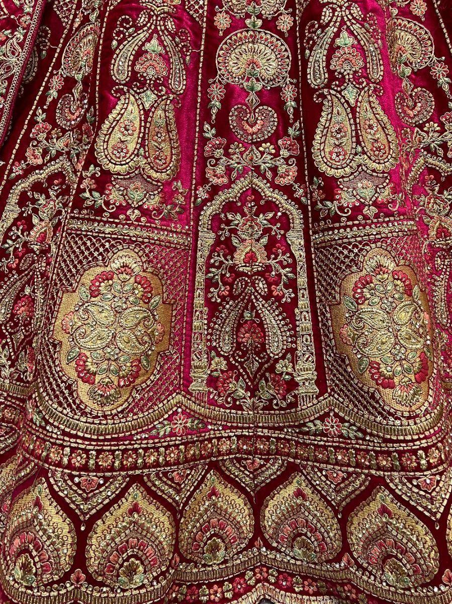 Rich maroon velvet lehenga with intricate gold paisley and floral embroidery, perfect for Indian ethnic wear.