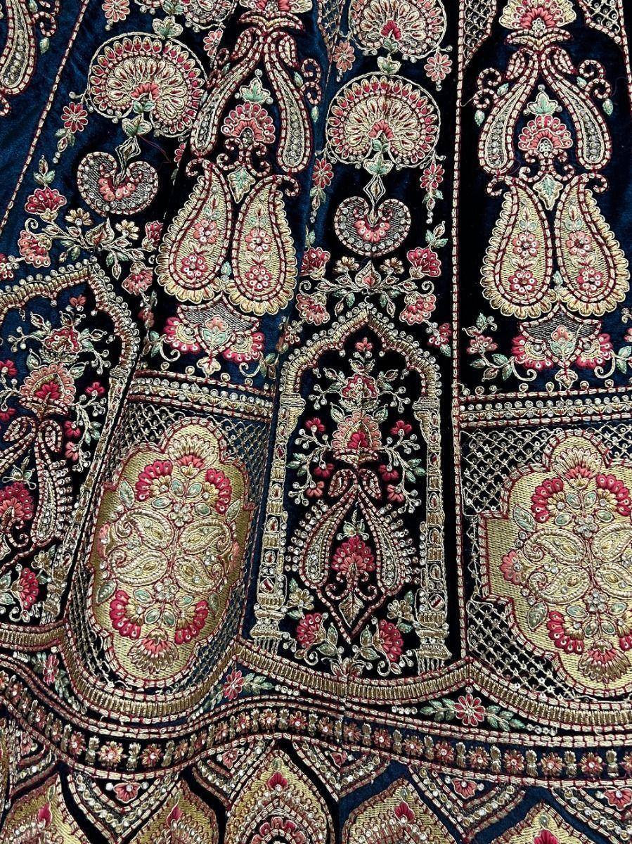 Richly embroidered Indian ethnic wear with paisley and floral motifs in gold, pink, and navy blue