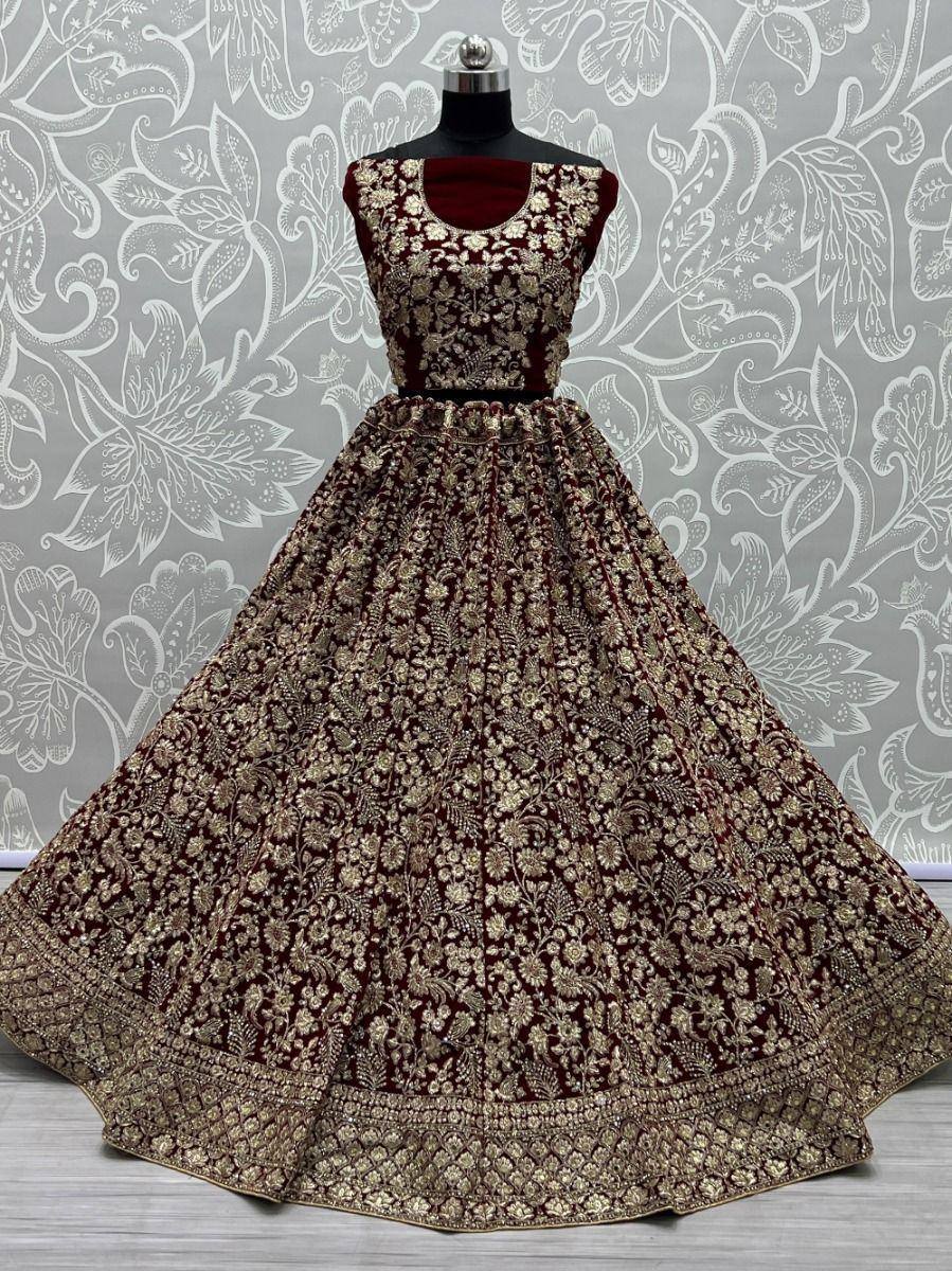 Maroon velvet lehenga choli with gold floral embroidery, perfect for Indian weddings and festive occasions.