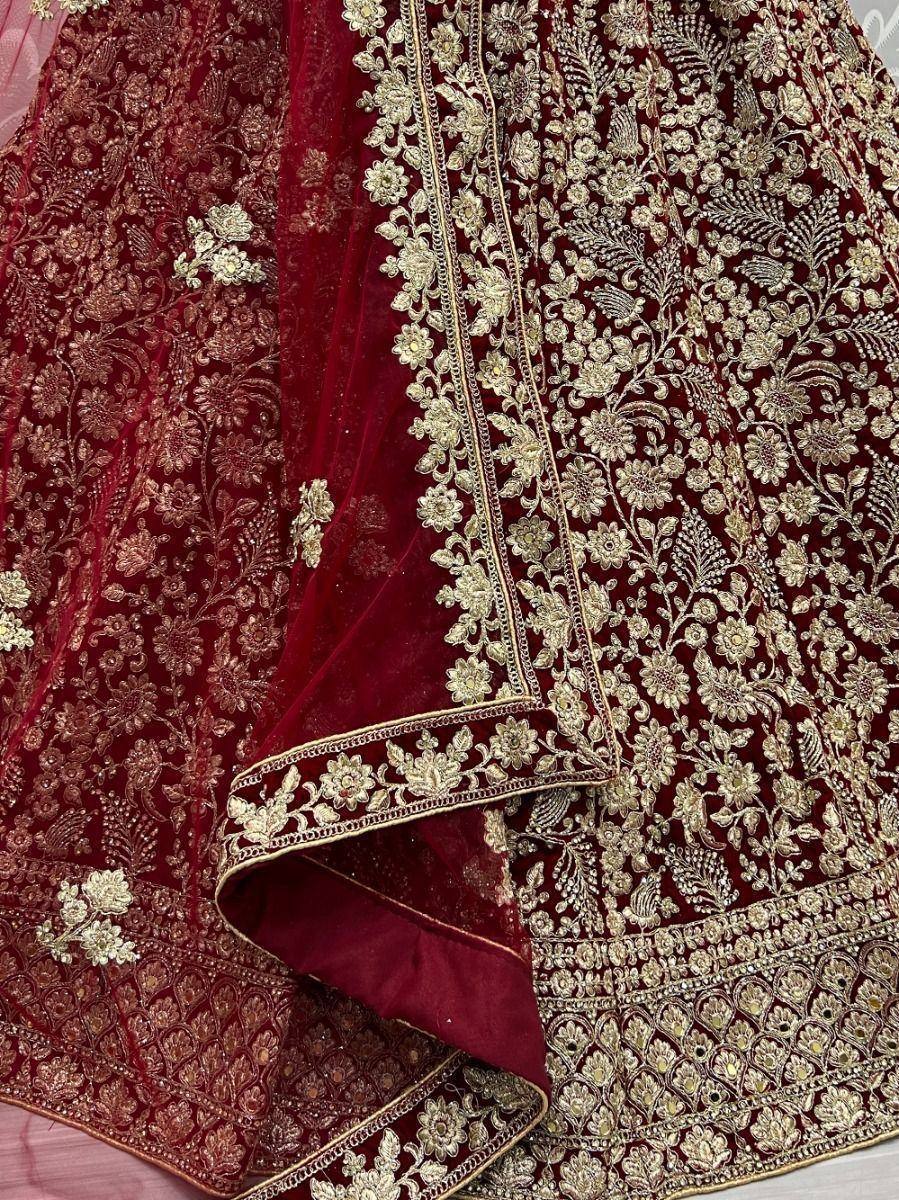 Rich maroon velvet lehenga with intricate gold floral embroidery, perfect for Indian weddings and festive occasions.