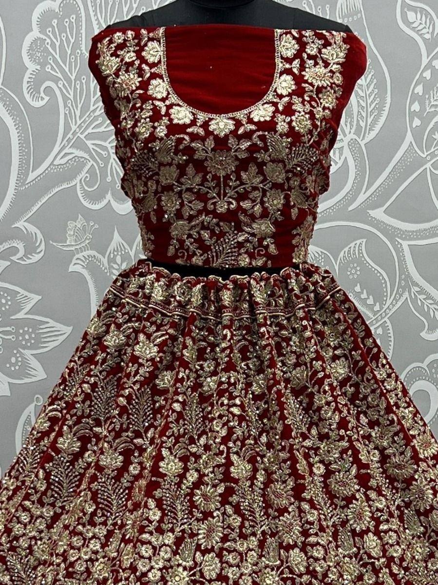 Red velvet lehenga choli with gold floral embroidery, perfect for Indian weddings and festive occasions.