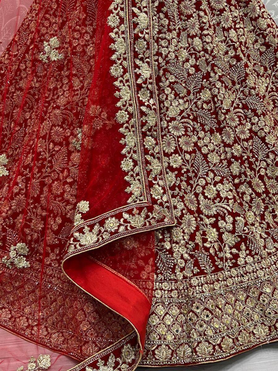 Red velvet lehenga with gold floral embroidery and intricate detailing, perfect for Indian weddings.