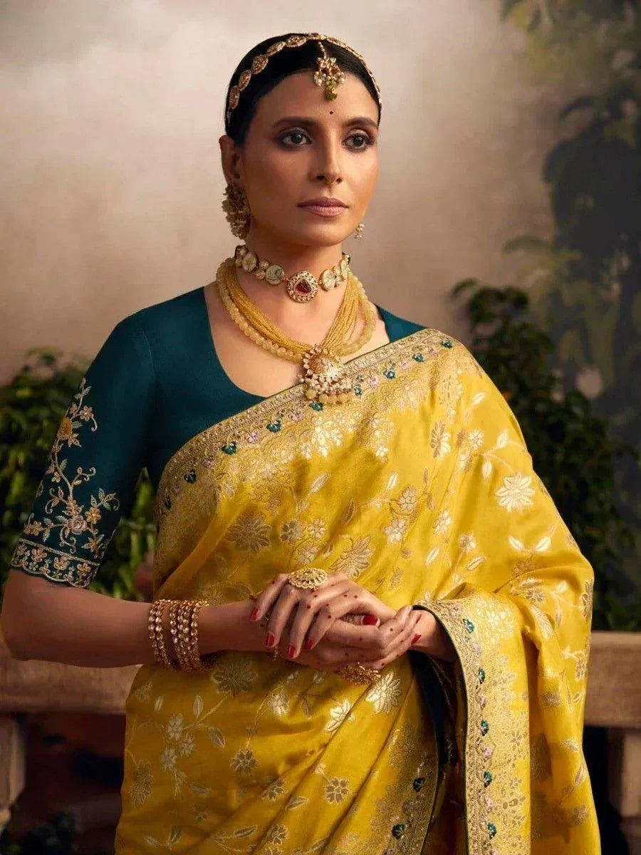 Elegant yellow embroidered saree with teal blouse, traditional Indian ethnic wear, perfect for weddings and festivals