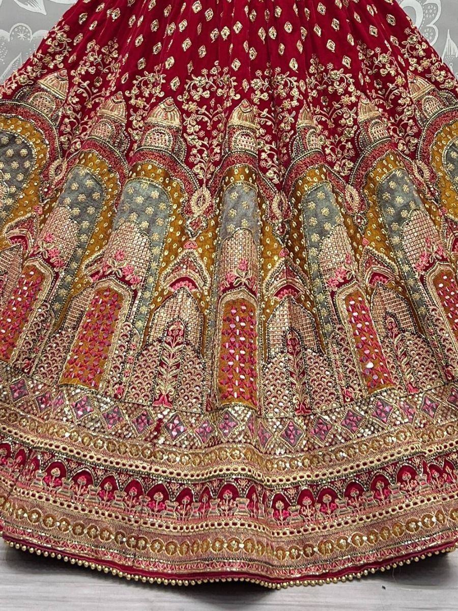 Richly embroidered red lehenga with gold and multicolor motifs, perfect for Indian weddings and festive occasions.