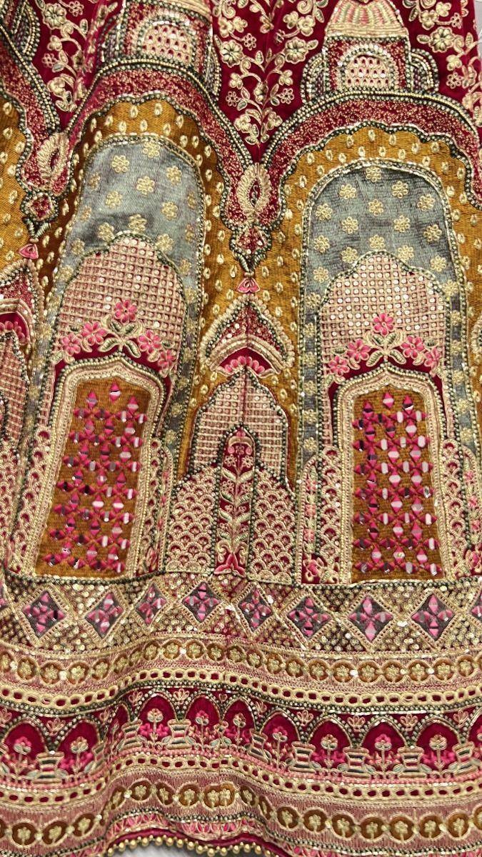 Richly embroidered Indian lehenga with gold, pink, and maroon motifs, perfect for weddings and festivals.