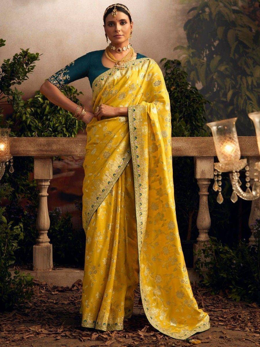 Yellow floral saree with gold embroidery, paired with teal blouse and traditional jewelry for ethnic wear