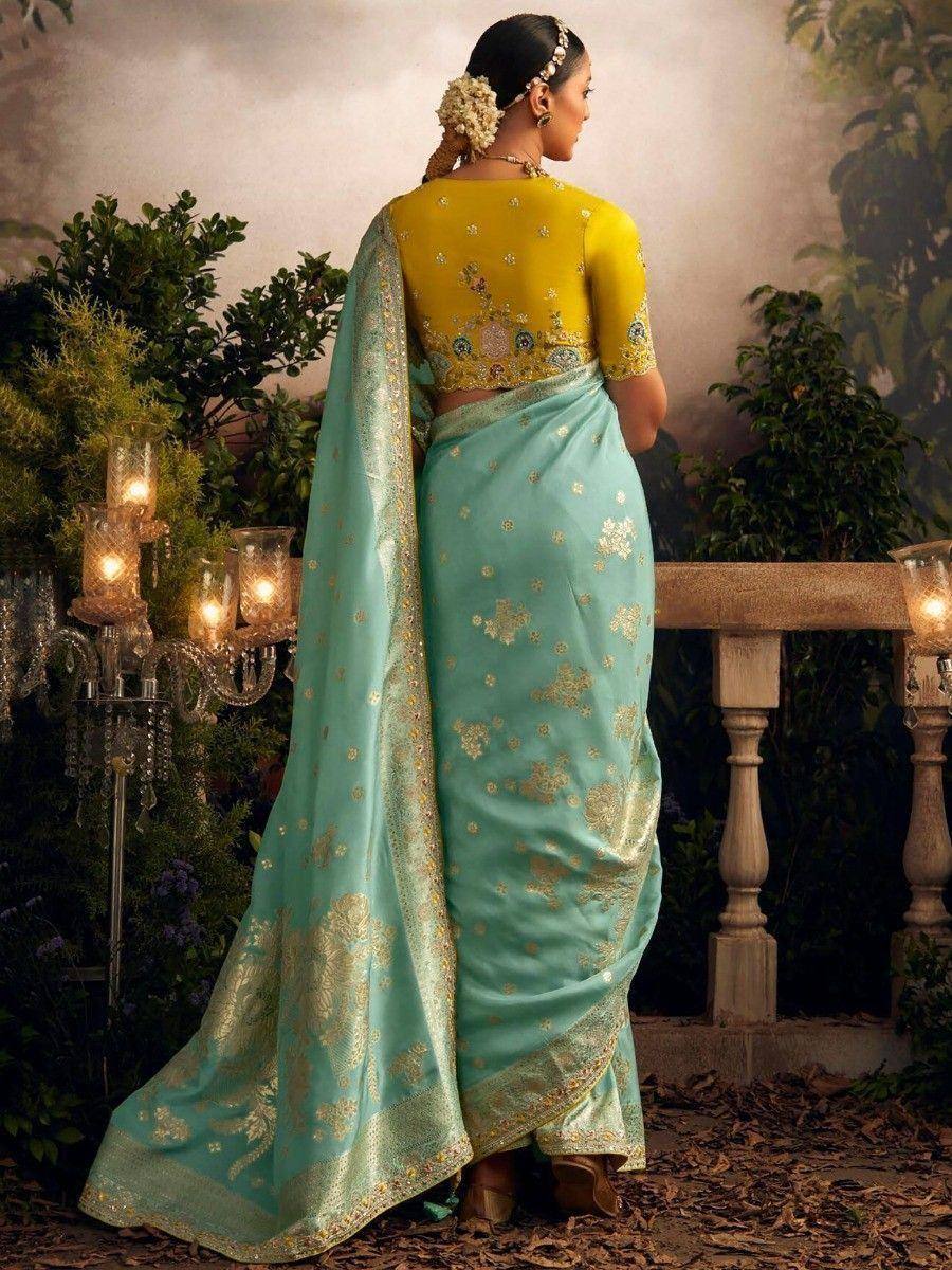 Elegant turquoise saree with gold floral embroidery, paired with yellow designer blouse, perfect for Indian ethnic occasions.
