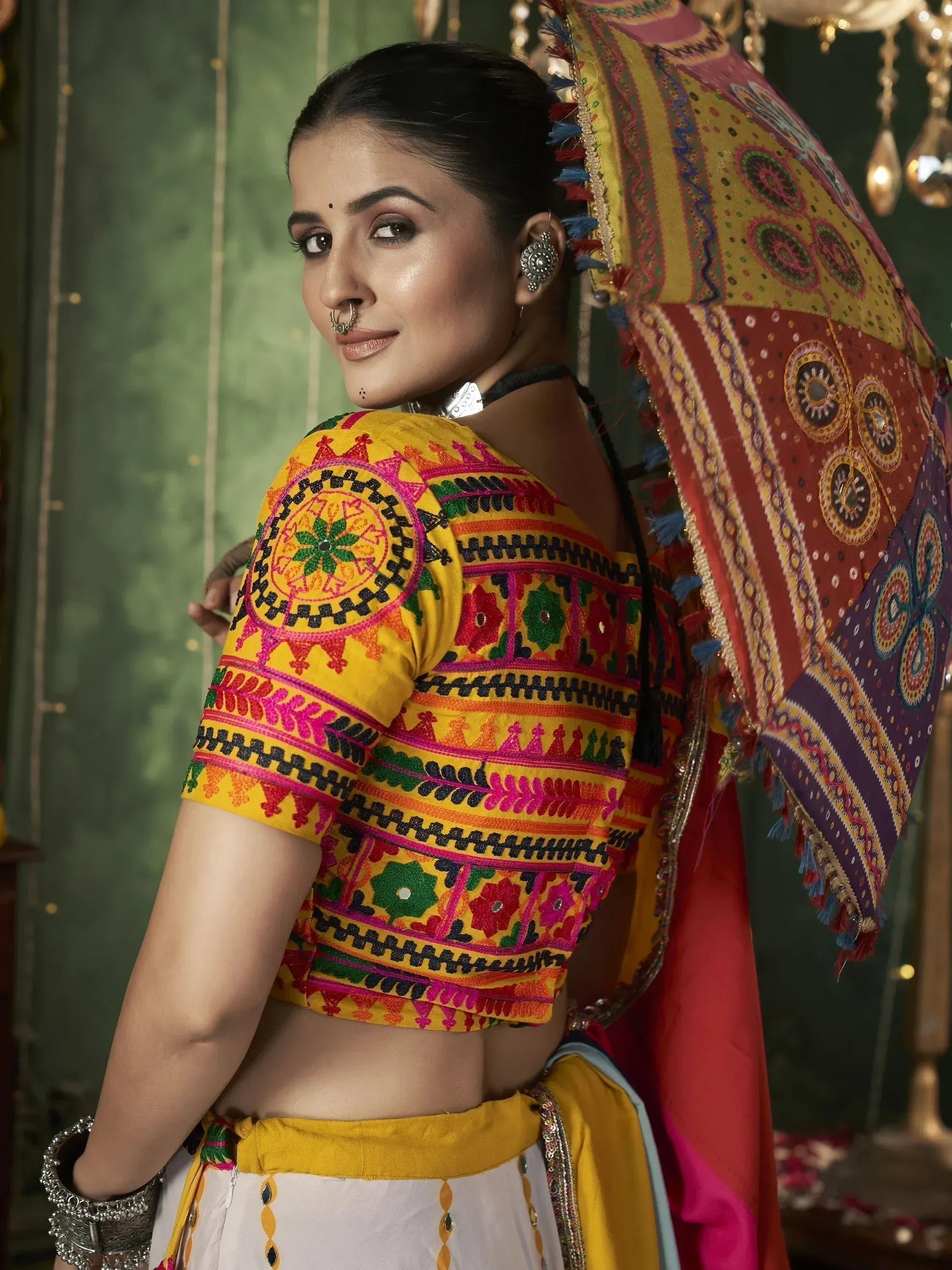 Vibrant yellow embroidered lehenga choli with colorful patterns and traditional accessories