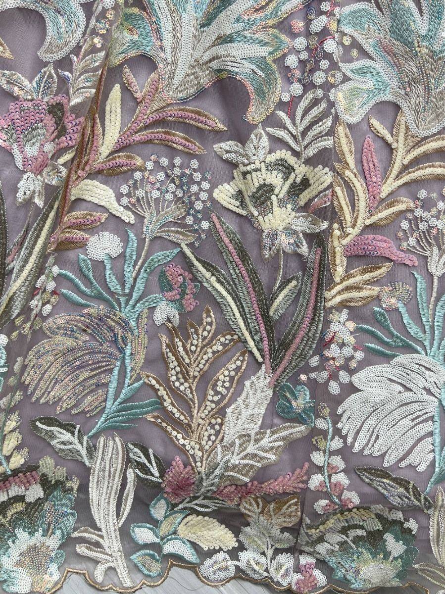 Intricate floral embroidery on sheer fabric, featuring sequins and threadwork for ethnic wear designs.