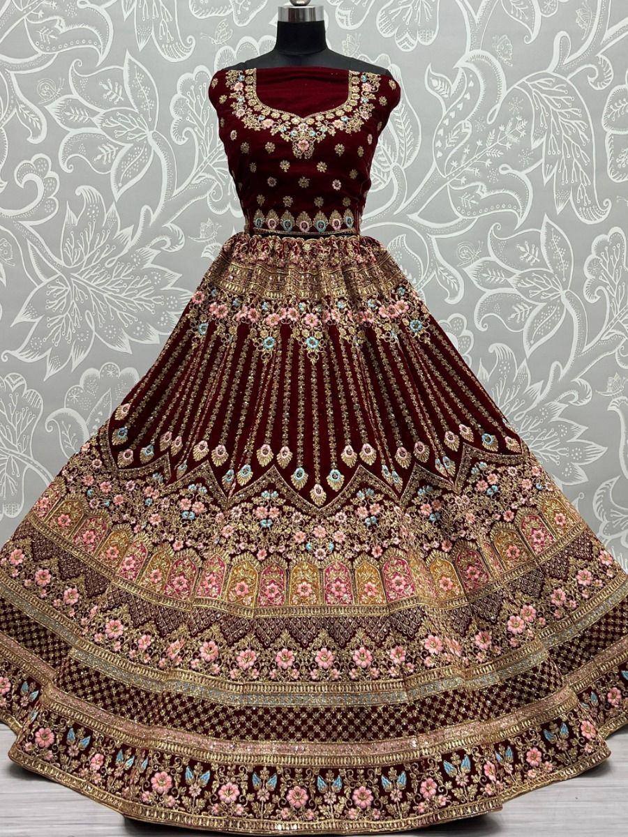 Maroon velvet lehenga choli with gold embroidery and floral motifs, perfect for Indian weddings and festive occasions.