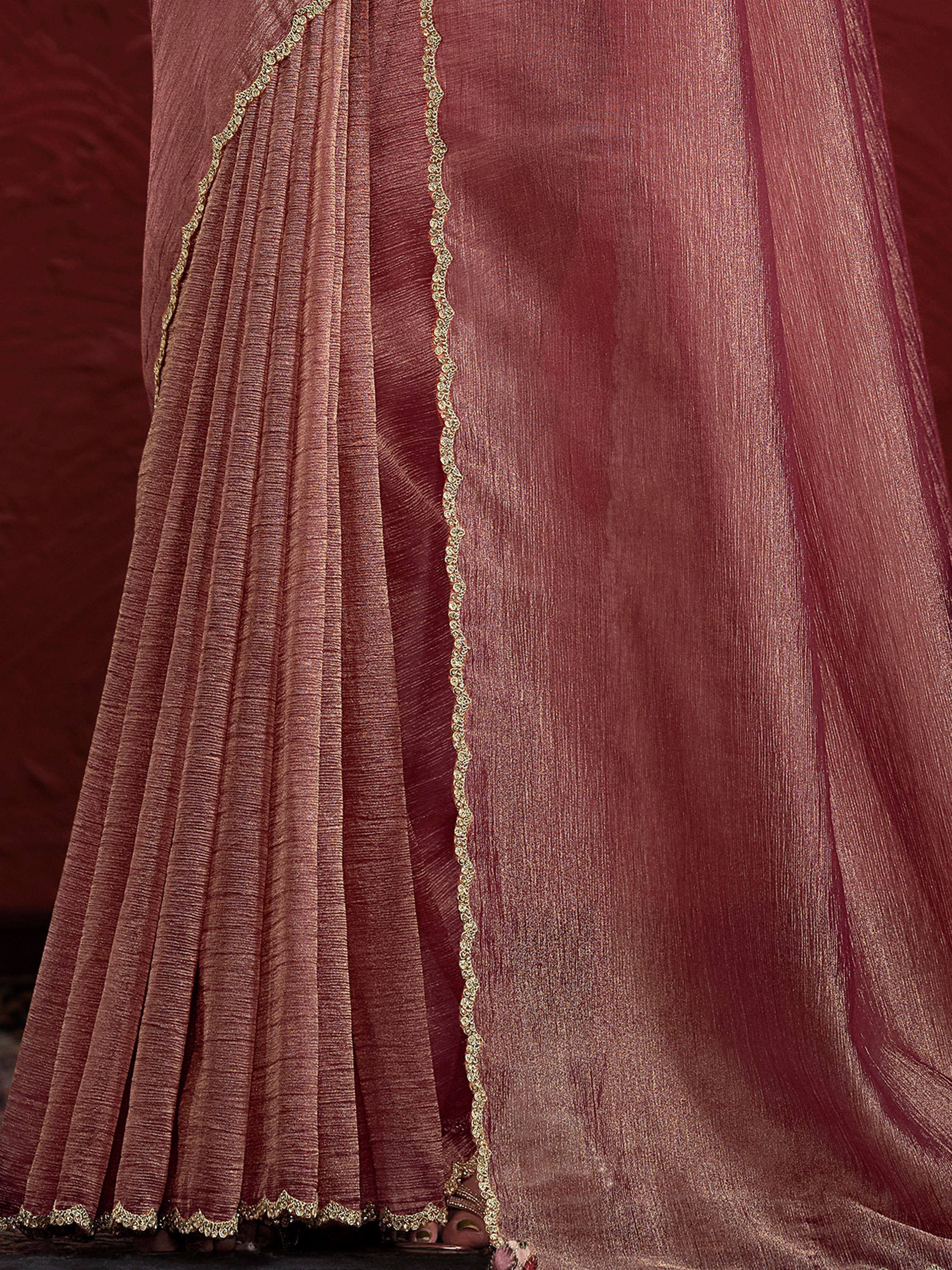 Rich maroon ethnic saree with gold embroidered border and pleated drape, perfect for festive occasions.