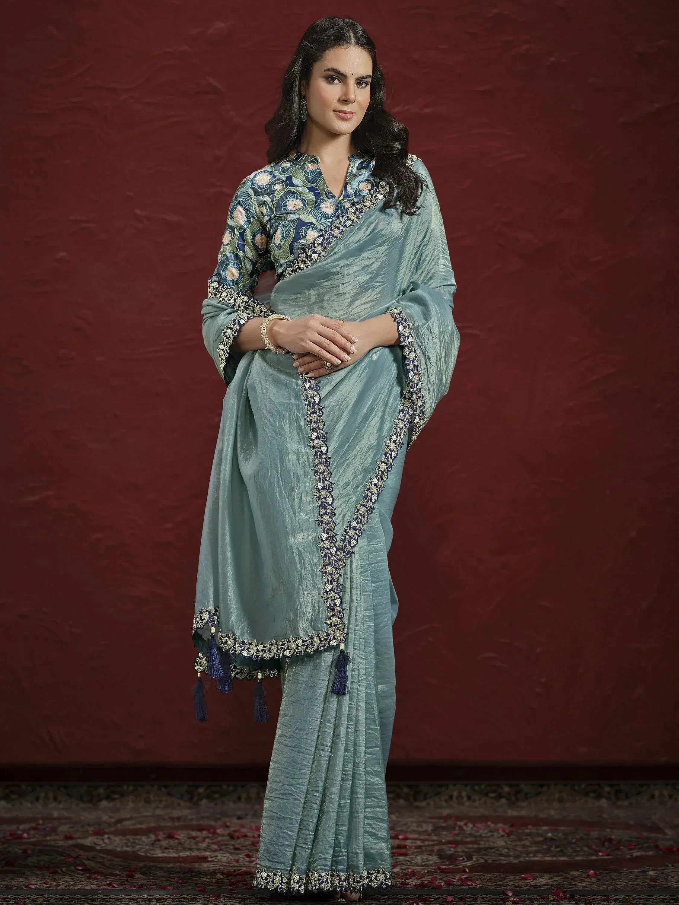Elegant light blue saree with floral embroidery and tassels, perfect for Indian ethnic occasions.