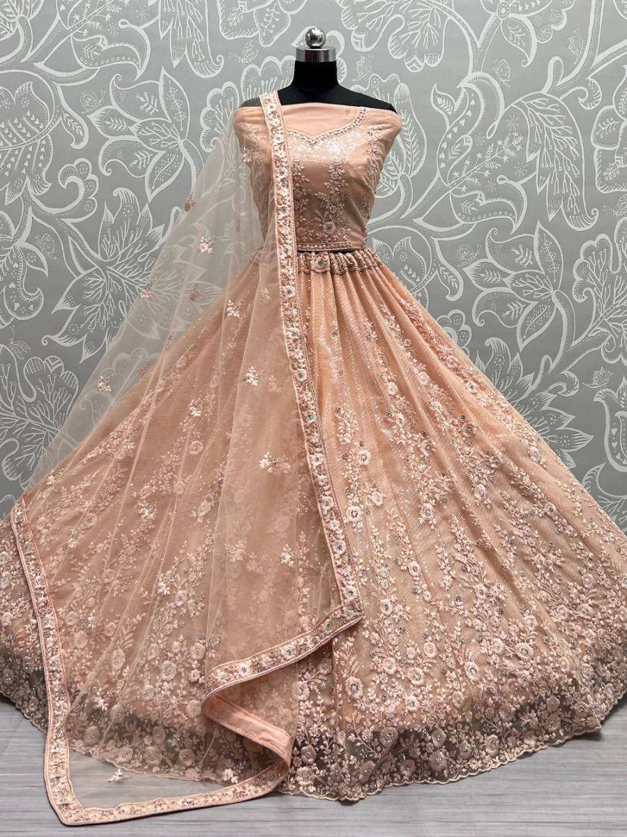 Elegant peach lehenga choli with floral embroidery and sheer dupatta, perfect for Indian weddings and festive occasions.