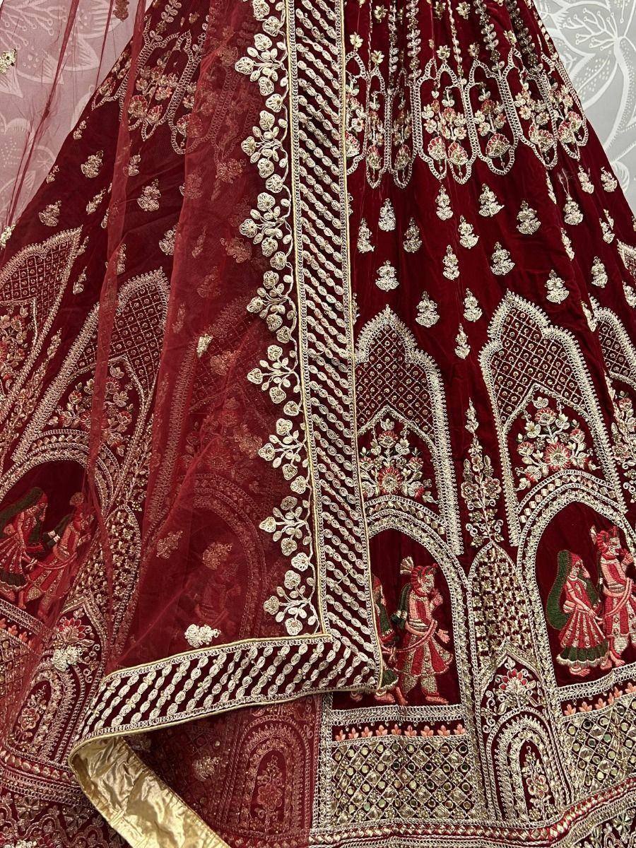 Maroon velvet lehenga with intricate gold embroidery and traditional Indian motifs, perfect for weddings and festive occasions.