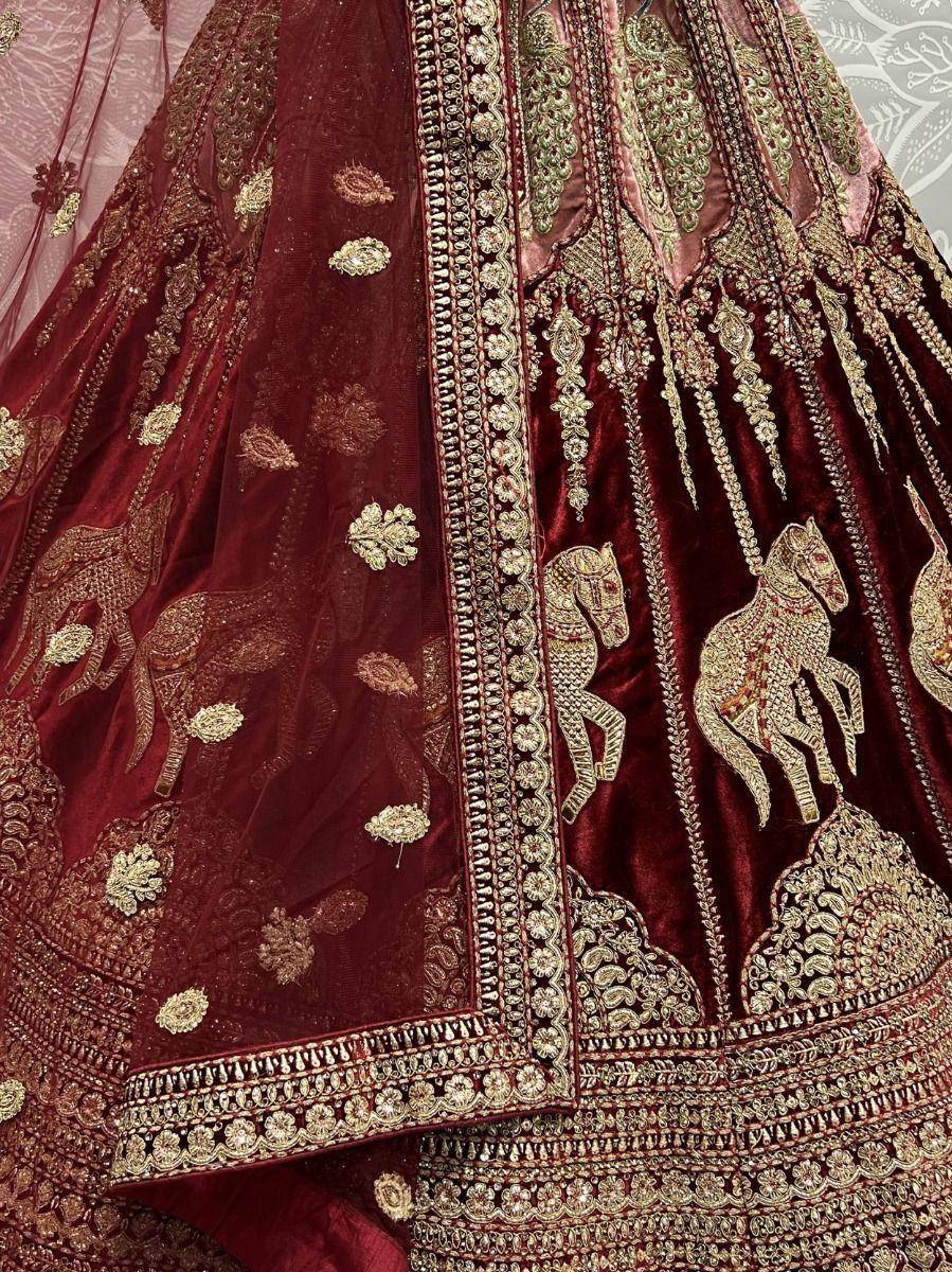 Maroon velvet lehenga with gold horse embroidery and intricate zari work, perfect for Indian weddings.