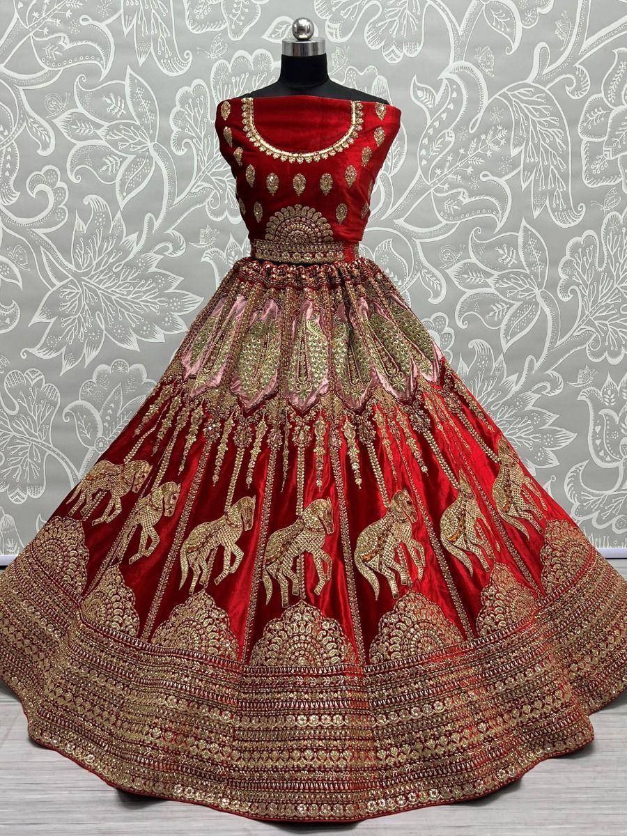 Red velvet lehenga choli with gold elephant embroidery and heavy zari work, perfect for weddings