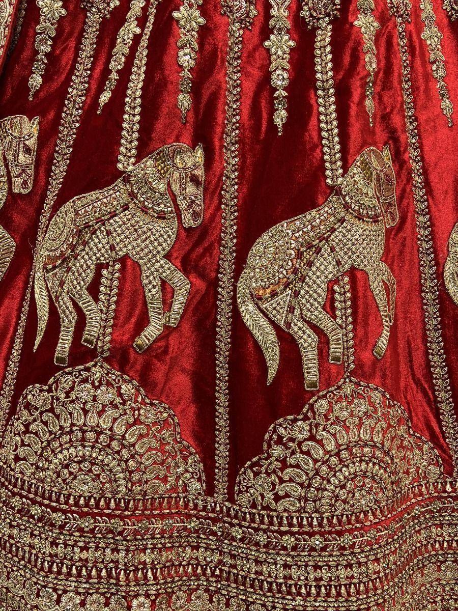 Red velvet lehenga with gold horse embroidery and intricate zari work