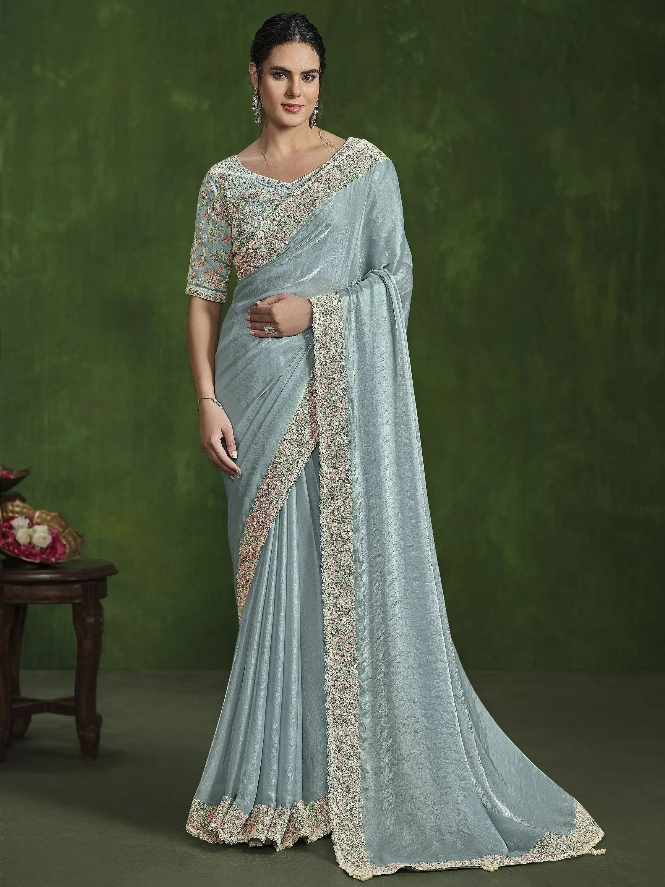Elegant light blue saree with floral embroidery and lace detailing, perfect for ethnic occasions.