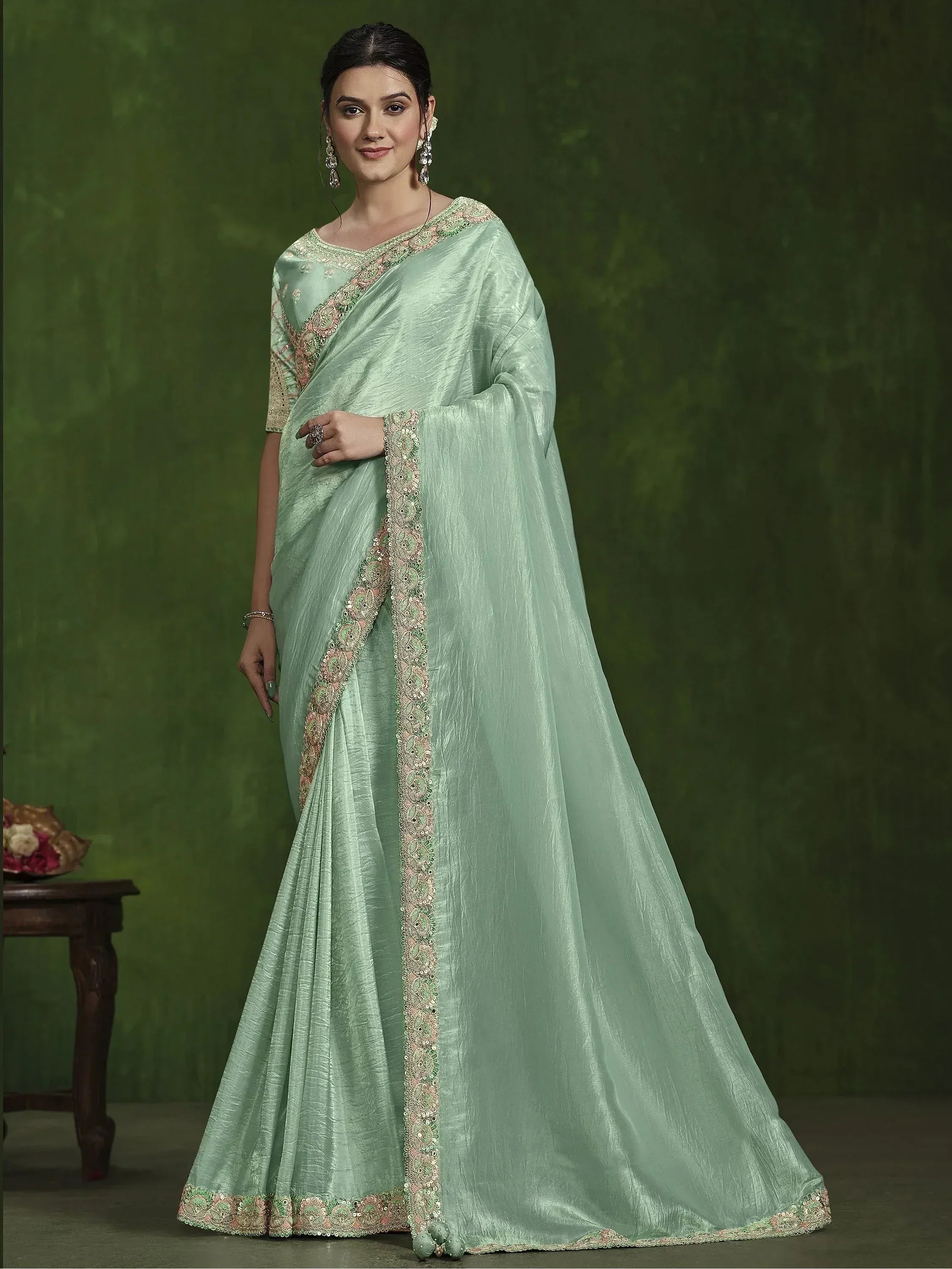 Mint green designer saree with intricate embroidery and sequin border, perfect for Indian ethnic occasions.