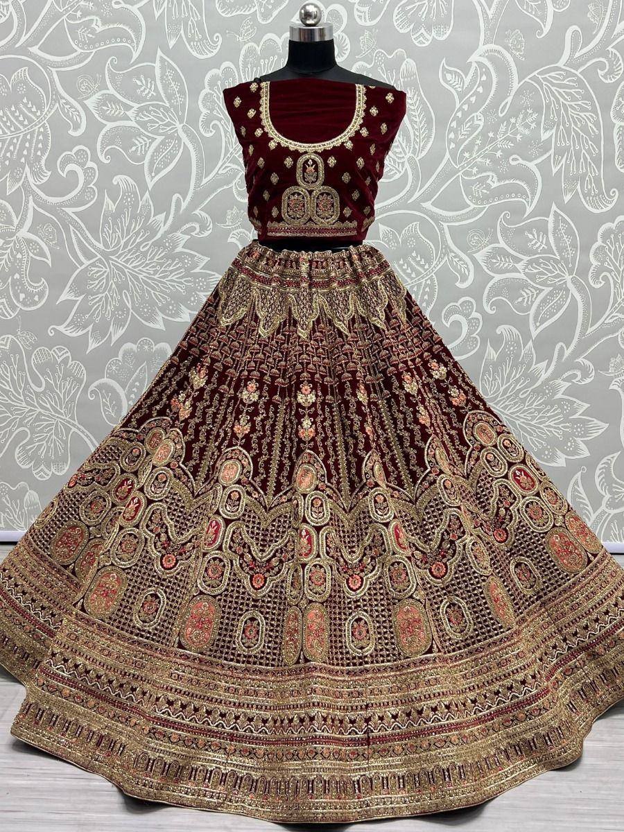 Maroon velvet lehenga choli with heavy gold embroidery, perfect for Indian weddings and festive occasions.