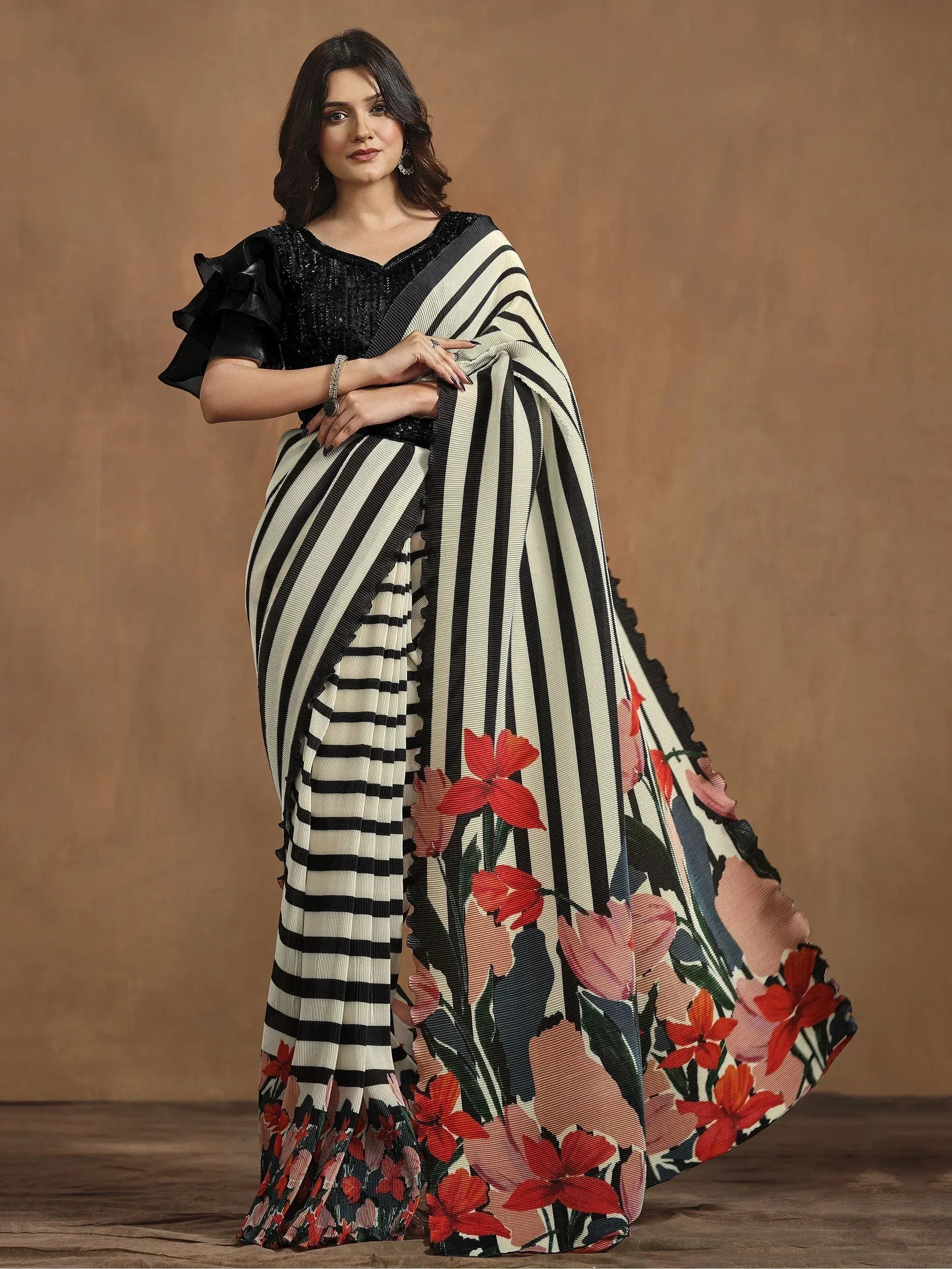 Woman in black and white striped saree with floral print, paired with sequined blouse, ethnic wear