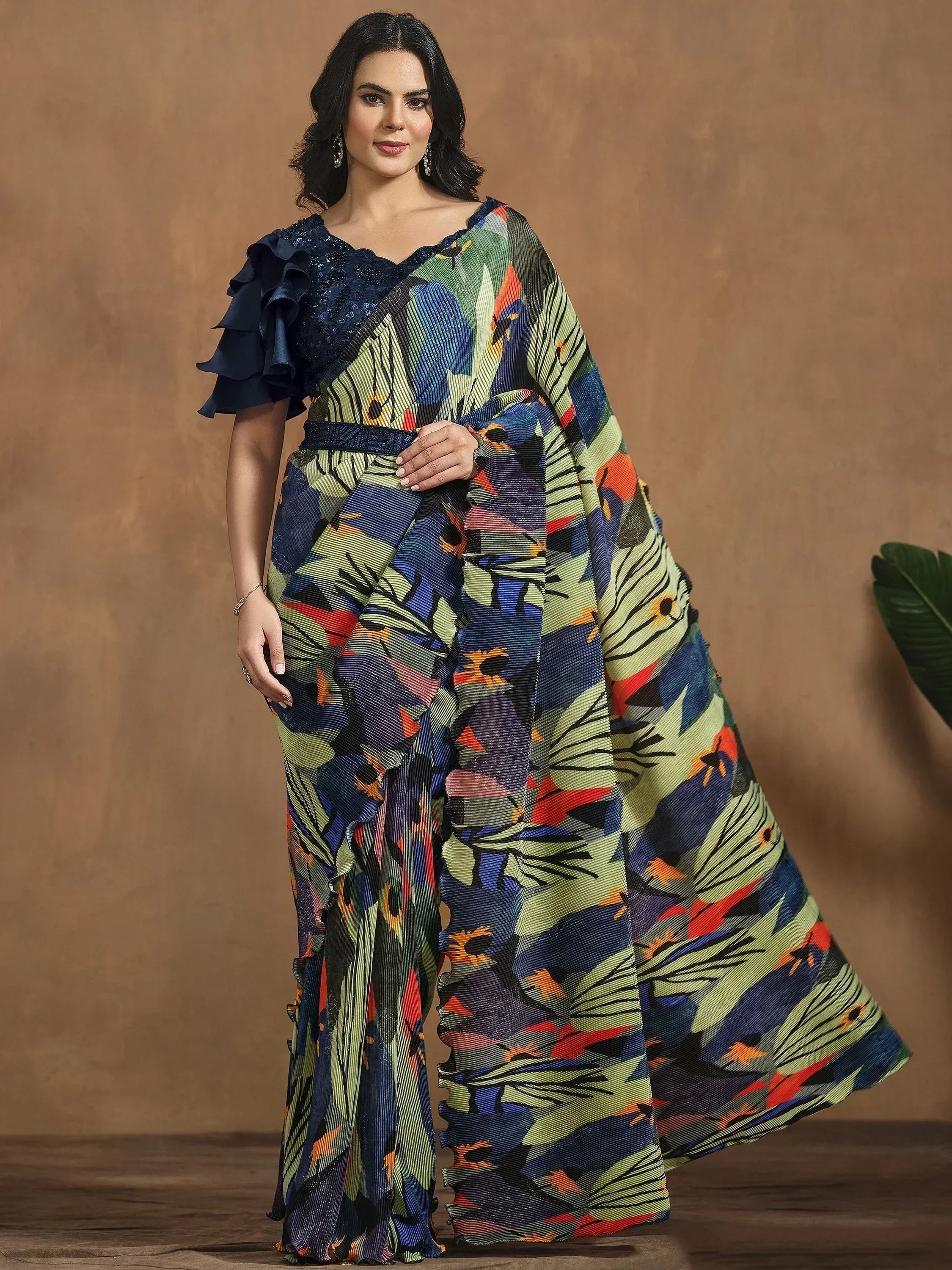 Woman in vibrant floral print saree with ruffled navy blouse, ethnic Indian wear