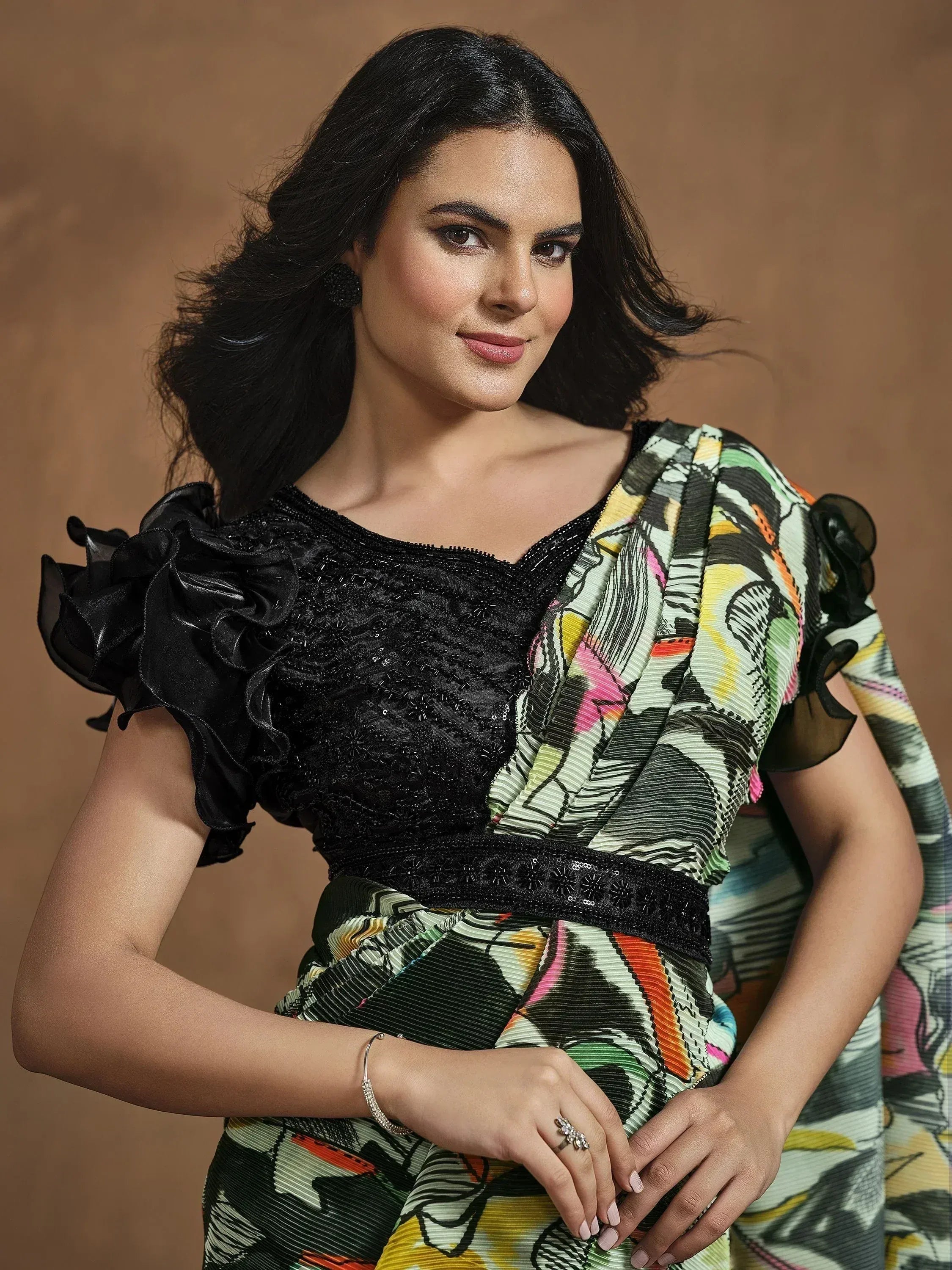 Woman in colorful printed saree with black beaded blouse and ruffled sleeves, ethnic wear