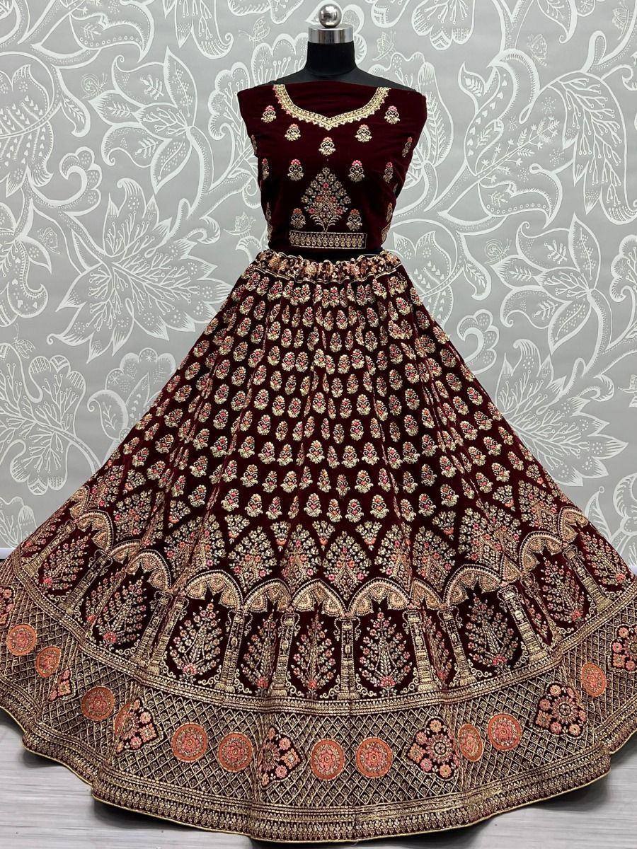 Maroon velvet lehenga choli with gold embroidery, perfect for Indian weddings and festive occasions.