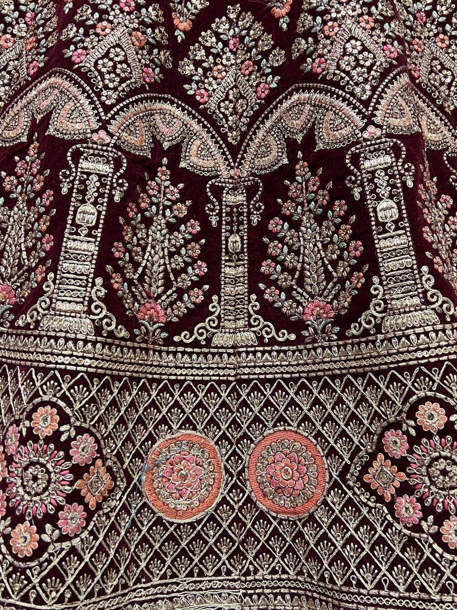 Richly embroidered maroon velvet lehenga with floral and paisley zari work, perfect for Indian ethnic wear.