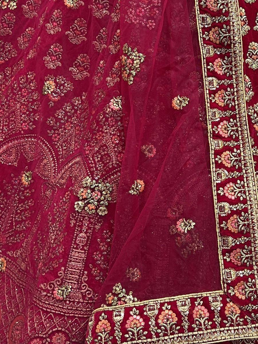 Rich maroon lehenga with intricate floral embroidery and golden border detailing, perfect for Indian ethnic wear.