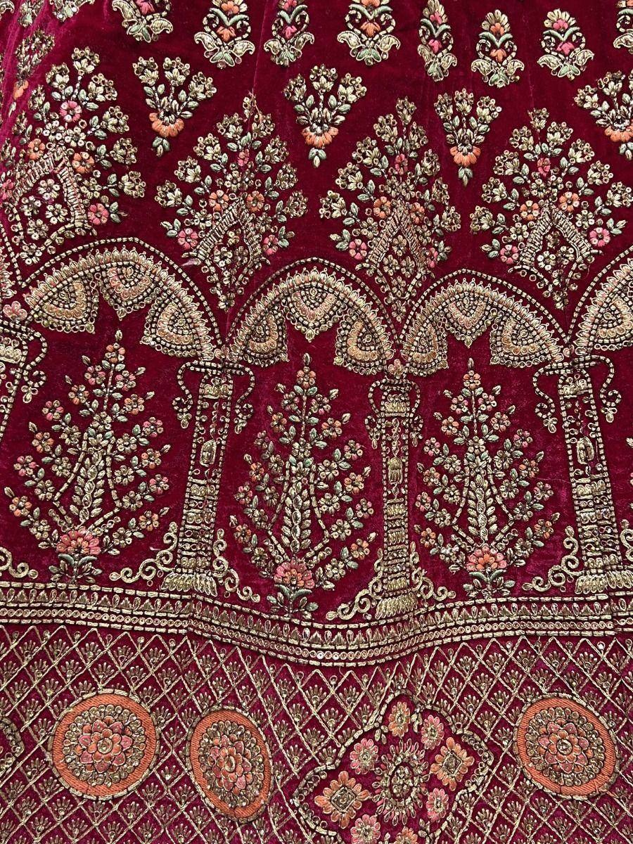 Rich maroon velvet lehenga with intricate gold floral embroidery and detailed border work