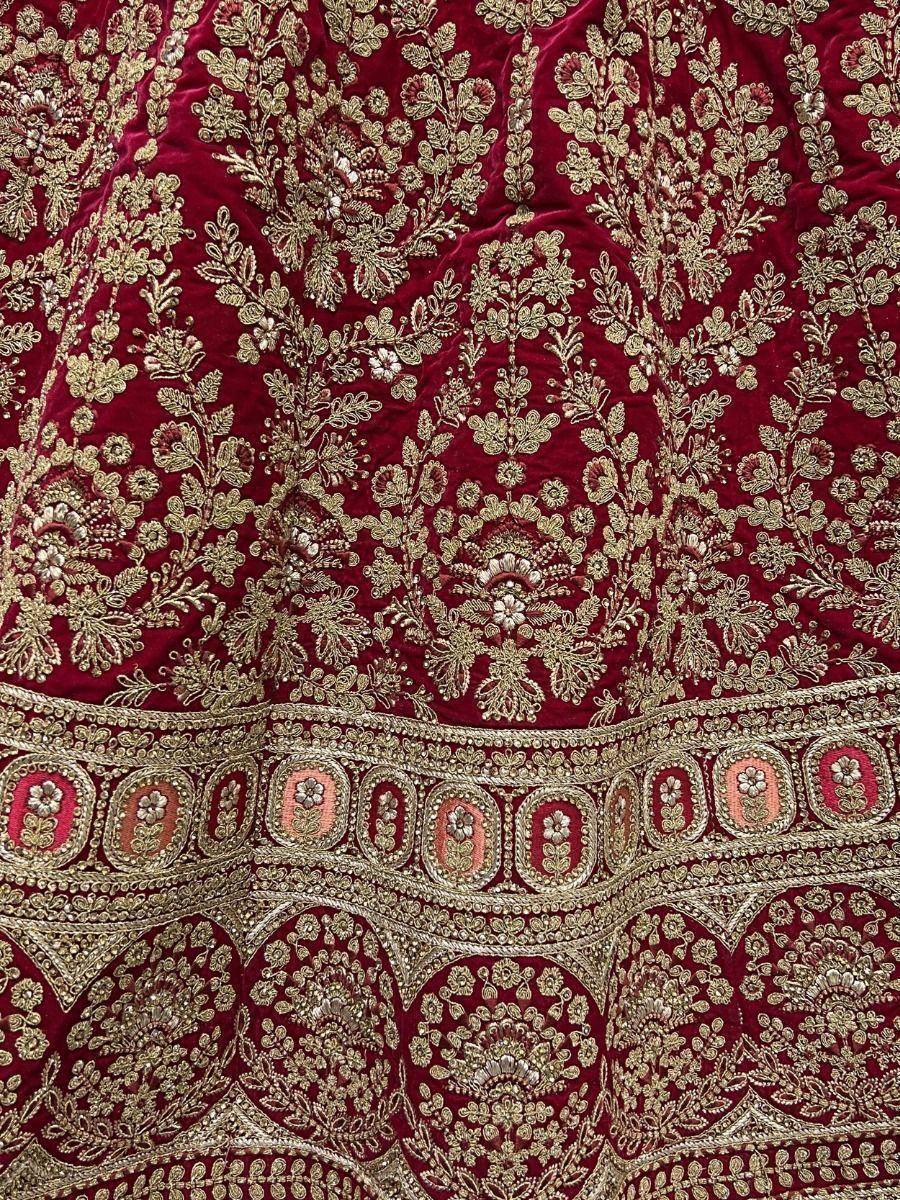 Rich maroon velvet lehenga with intricate gold floral embroidery and border detailing