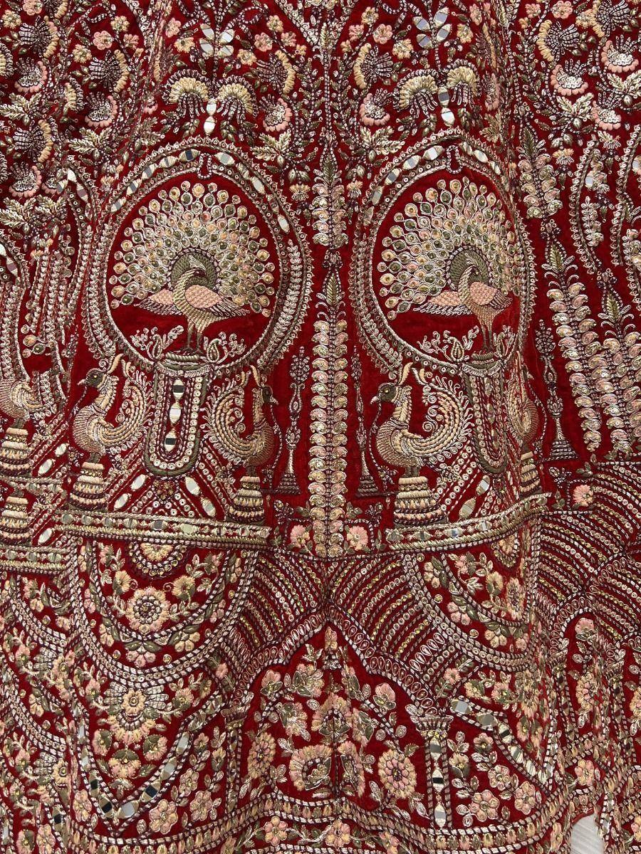 Richly embroidered red lehenga with peacock motifs and mirror work, ideal for Indian ethnic wear
