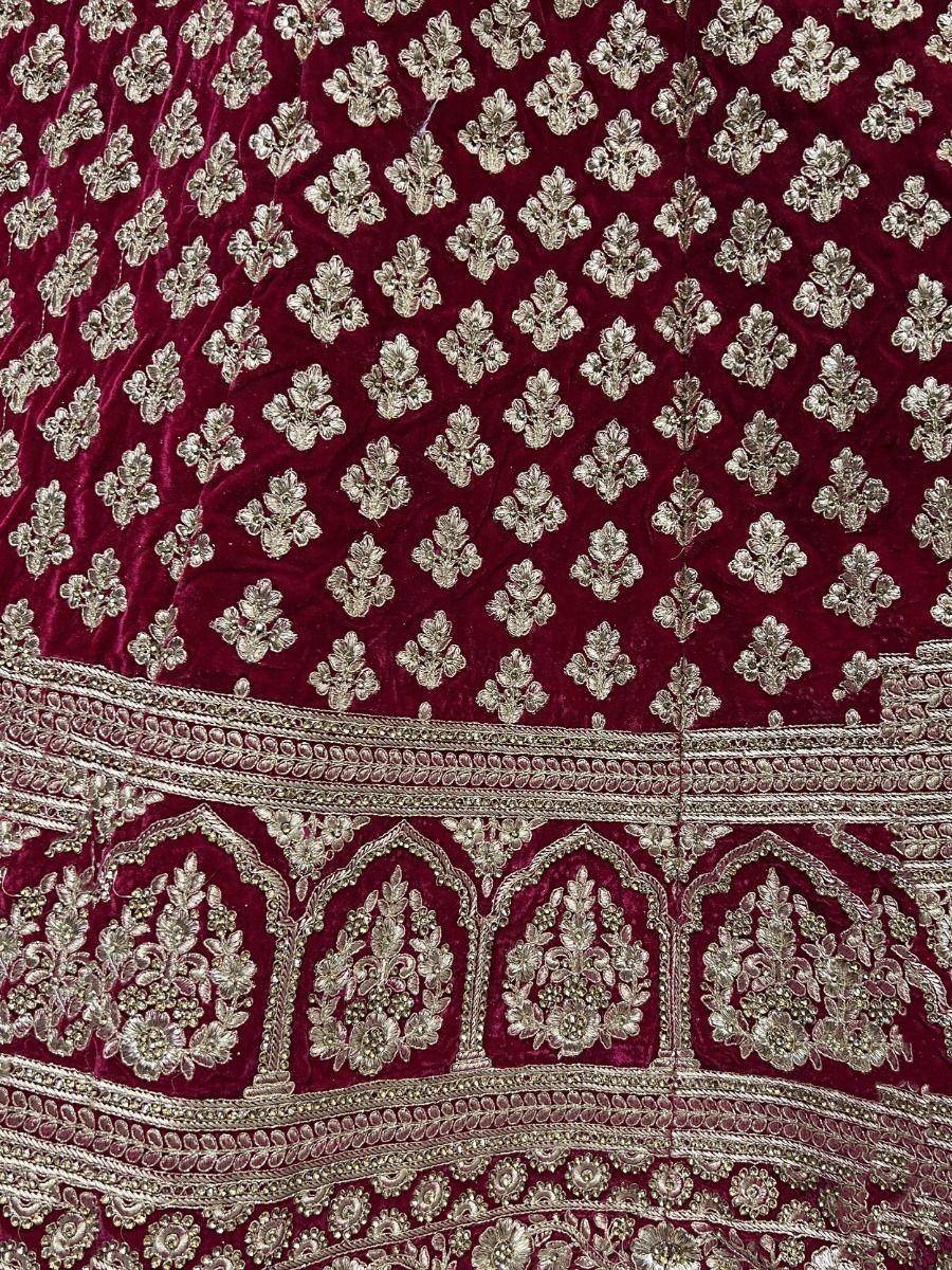 Rich maroon velvet lehenga with intricate silver embroidery and floral motifs, perfect for Indian ethnic wear.