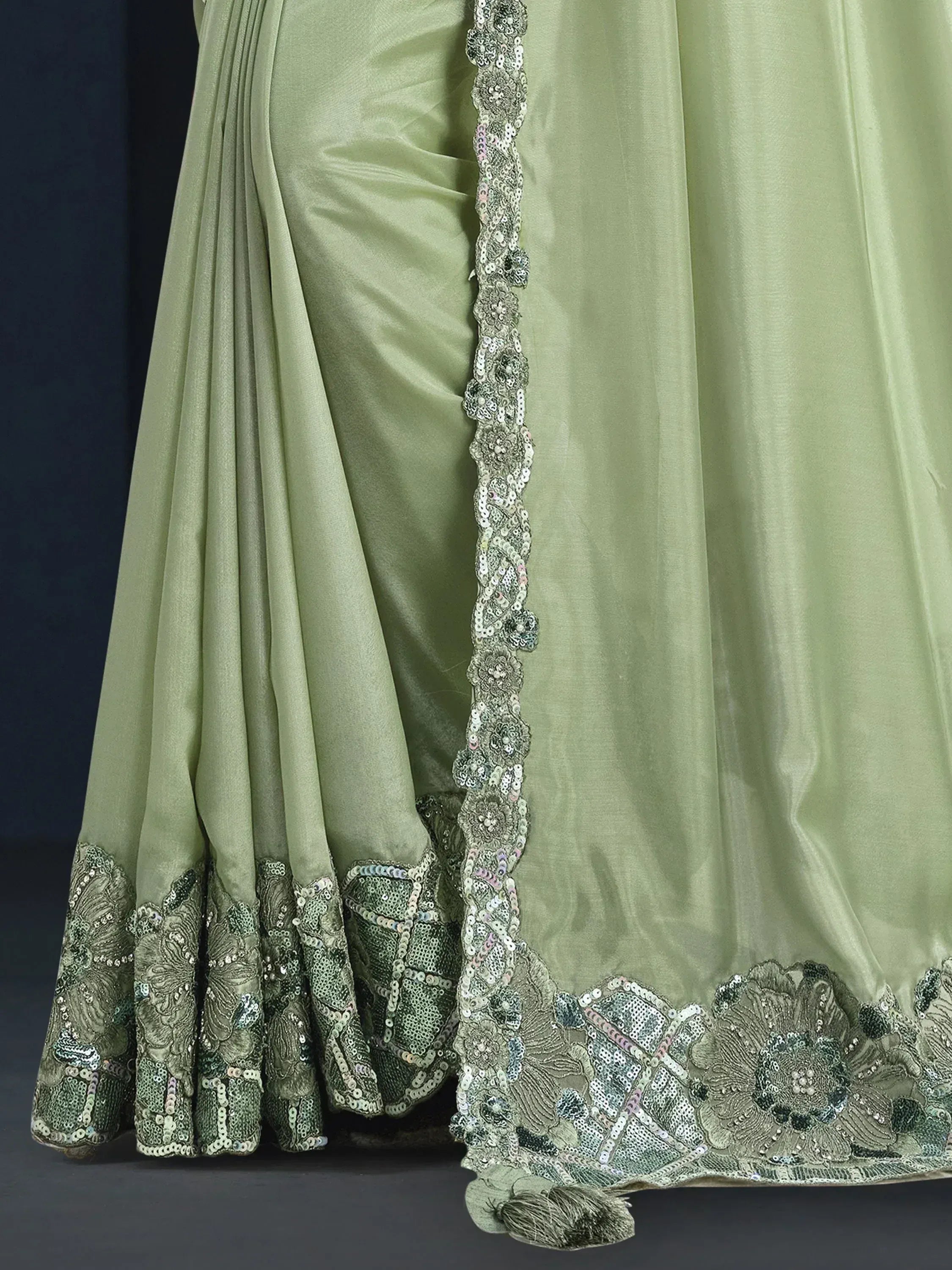 Light green satin lehenga with intricate floral sequin embroidery and tassel detailing, perfect for ethnic occasions.