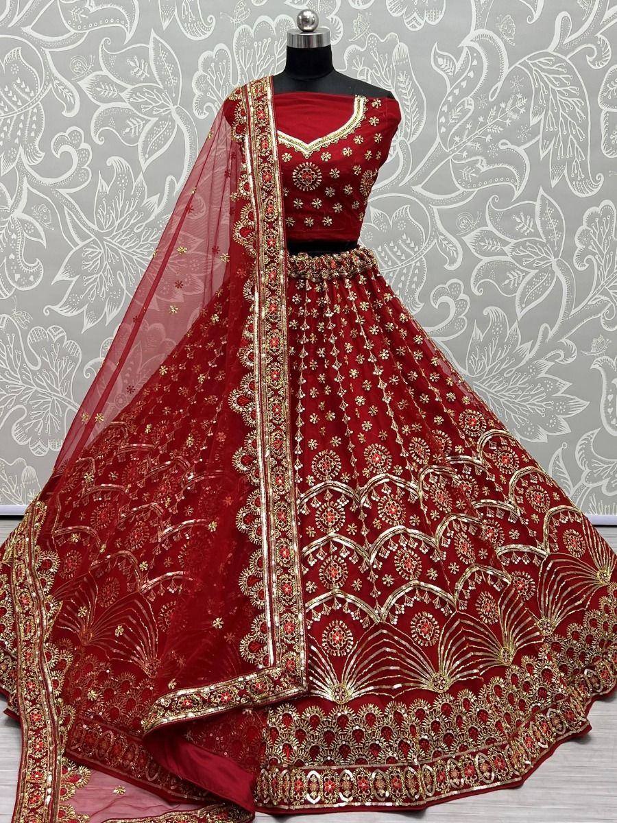 Red designer lehenga choli with gold embroidery and sheer dupatta, perfect for Indian weddings and festive occasions.